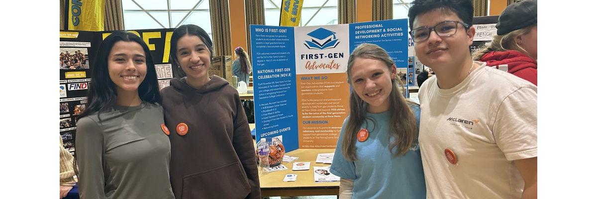 Students standing in front of a table at an involvement fair with a tri-fold poster behind them