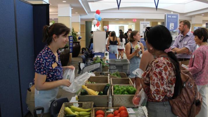 People talking over boxes of fresh produce