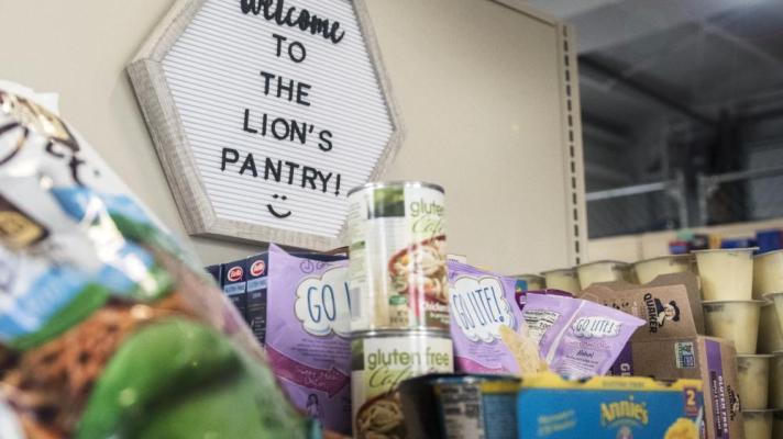 Sign that says Welcome to the Lion's Pantry behind a stack of canned goods
